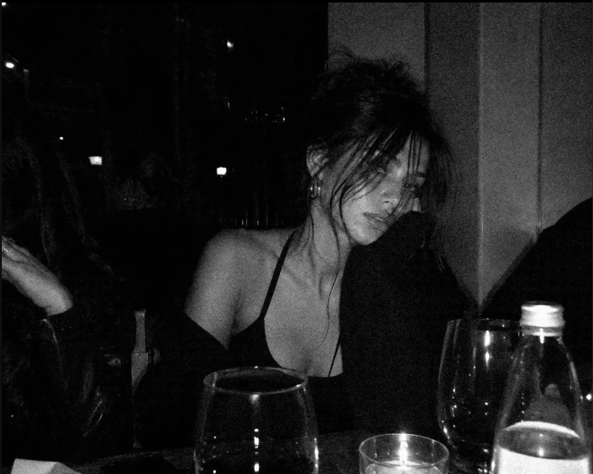 Black-and-white photograph of MIXXIE seated at a bar table
